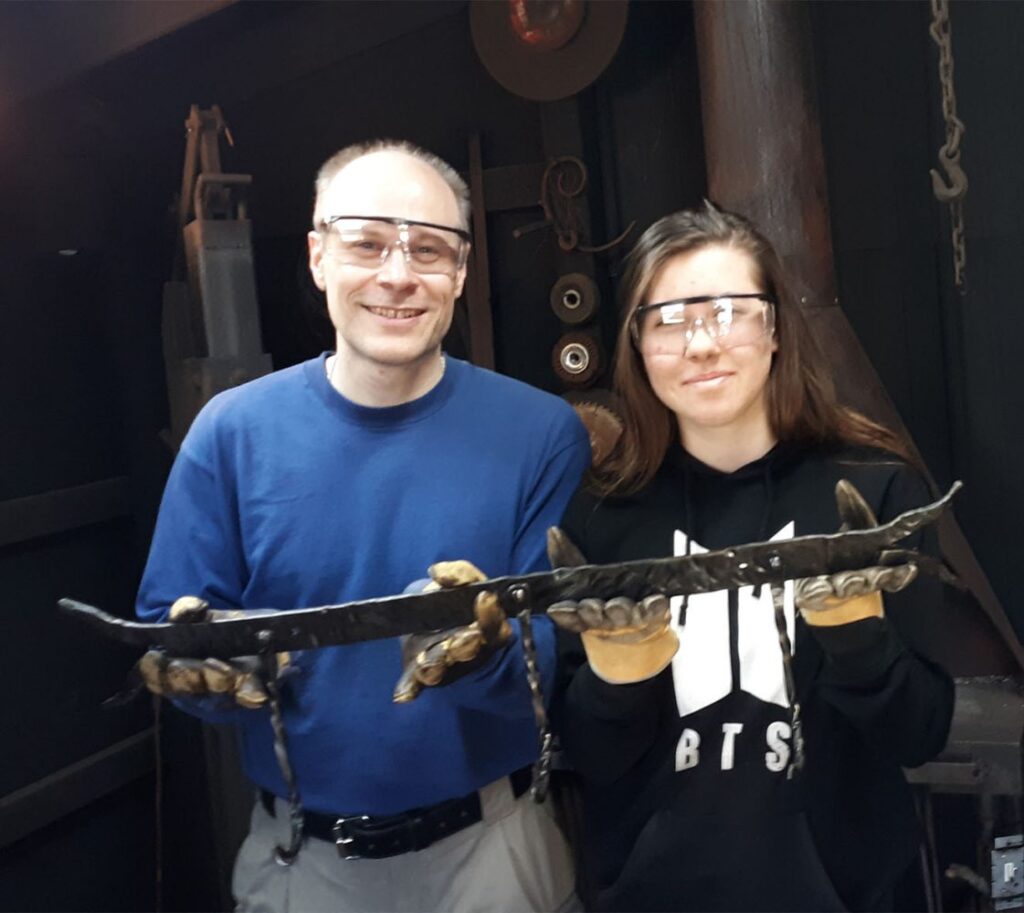 People holding hand forged item